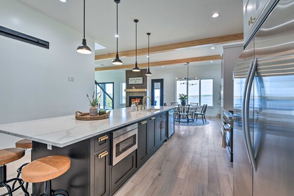 A modern kitchen with a large island, stainless steel appliances, and pendant lighting. - Entire Luxury Lake Granbury Cliffside Home w/ Deck (Granbury)