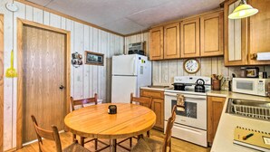 A kitchen with wooden cabinets, a refrigerator, a stove, and a microwave. - Secluded Remer Cabin w/ Lake Access! (Remer)