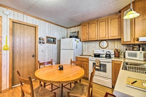 A kitchen with wooden cabinets, a refrigerator, a stove, and a microwave. - Secluded Remer Cabin w/ Lake Access! (Remer)