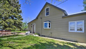 A two-story house with a front porch, a small deck, and a picnic table. - 'the Farmstead' on 10 Acres w/ Mountain Views! (Red Lodge)