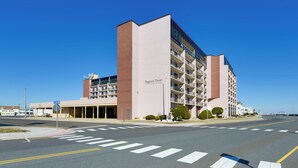 A multi-story hotel with a prominent "Regency Tower" sign, a covered parking area, and a clear blue sky.