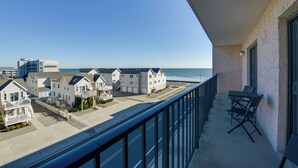 A balcony with a view of a beach and houses.