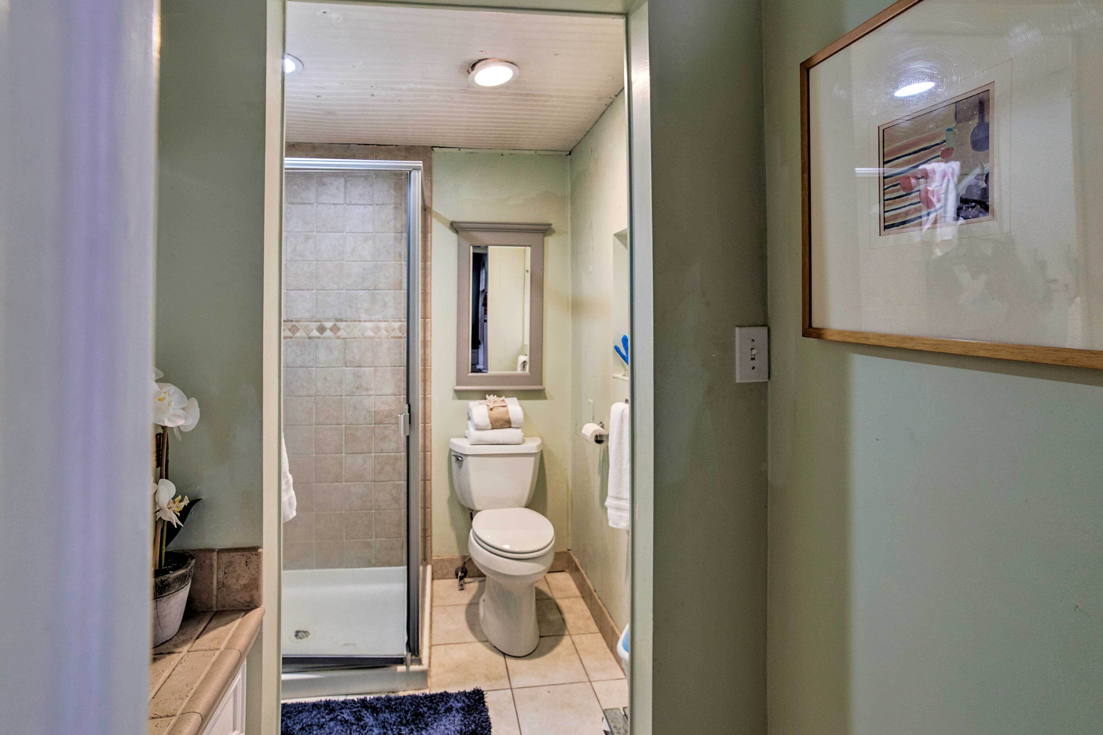 A bathroom with a shower, toilet, and sink.