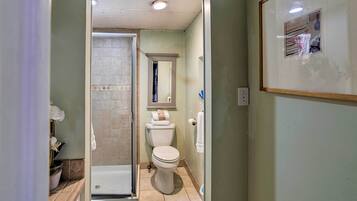 A bathroom with a shower, toilet, and sink.