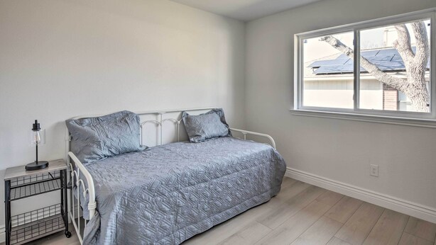 A bedroom with a bed, a ceiling fan, a window, and a nightstand. - Stunning Plano Home w/ Private Pool & Hot Tub (Plano)