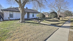 A residential house with a white exterior, a dark roof, and a well-maintained lawn. - Stunning Plano Home w/ Private Pool & Hot Tub (Plano)