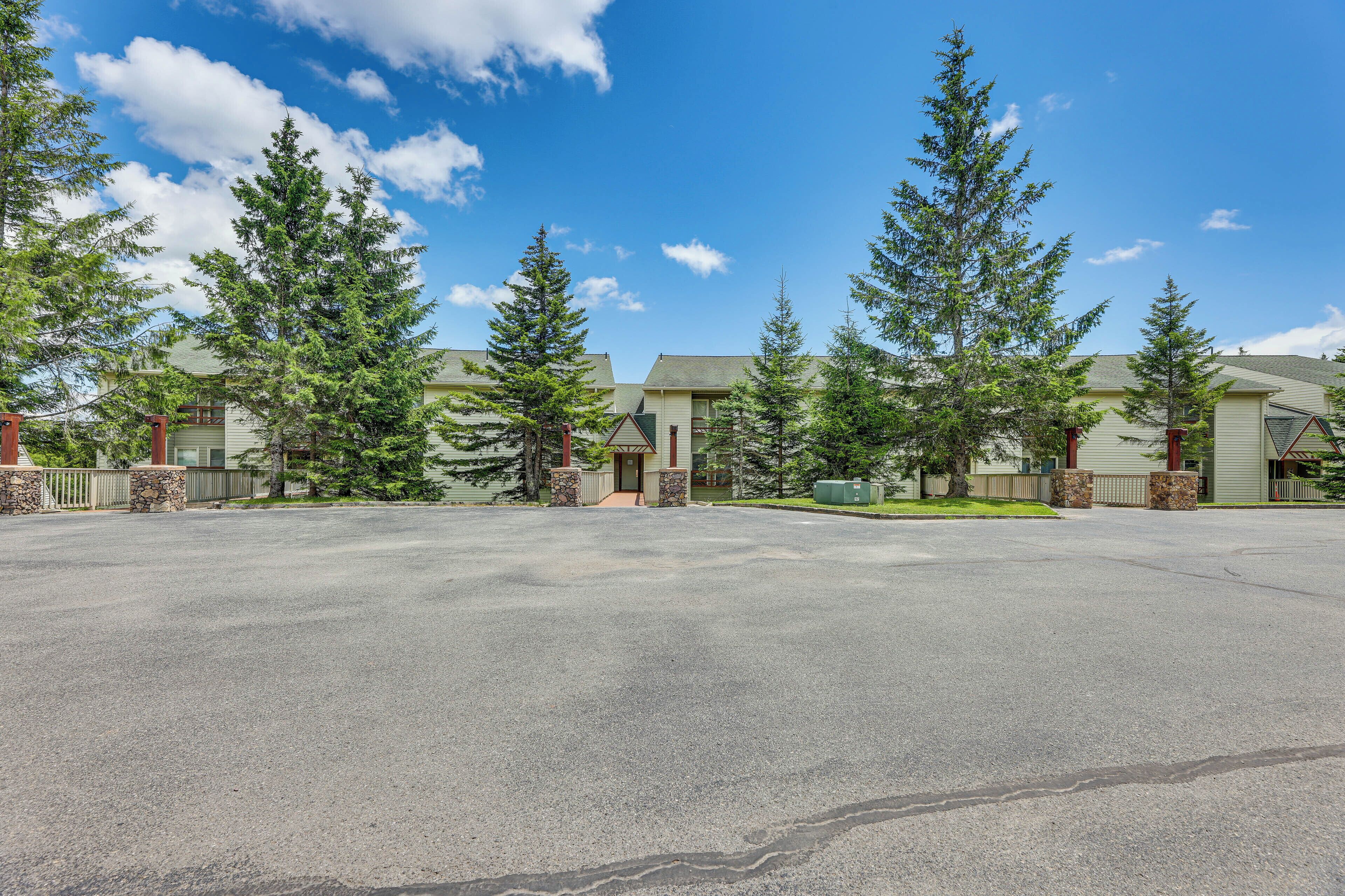 A residential area with multiple houses, a paved driveway, and a clear sky.
