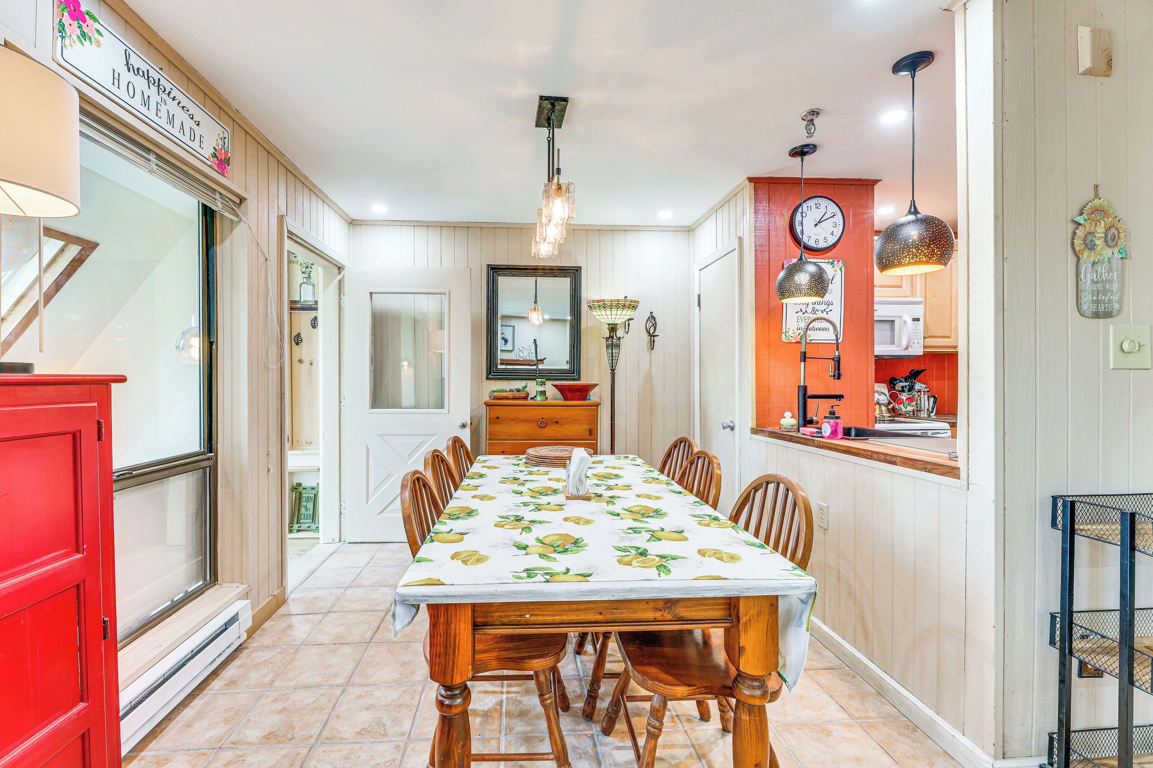Un espace repas avec une longue table, des chaises et un lustre.
