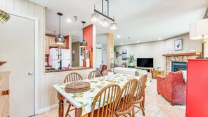 A spacious living area with a dining table, chairs, and a red sofa. - Walk to Slopes: Snowshoe Condo w/ Sunroom (Snowshoe)