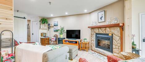 A cozy living room with a fireplace, a television, and comfortable seating.