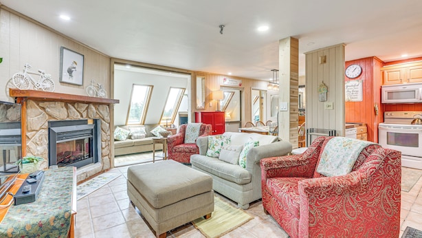 A cozy living room with a fireplace, a dining area, and a kitchen. - Walk to Slopes: Snowshoe Condo w/ Sunroom (Snowshoe)