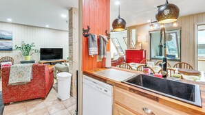 A compact living space with a kitchenette, a sofa, a television, and a dining area. - Walk to Slopes: Snowshoe Condo w/ Sunroom (Snowshoe)