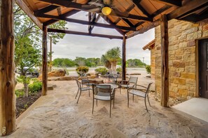 An outdoor patio with stone flooring, a wooden pergola, and a stone building. - Quaint Fredericksburg Studio w/ Shared Hot Tub (Fredericksburg)