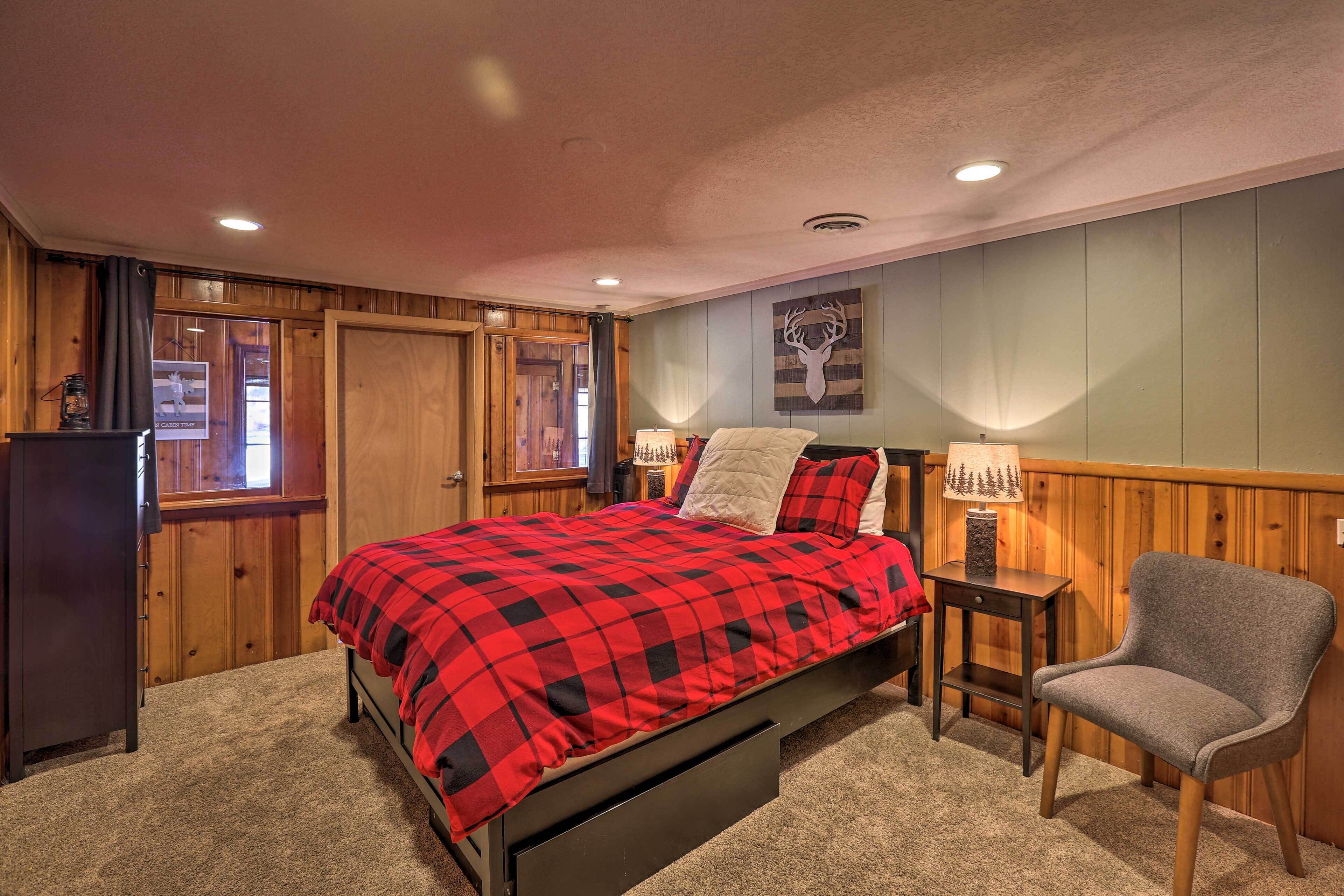 A bedroom with a bed, a chair, a nightstand, and a wall-mounted lamp.