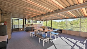 A spacious room with a large table, benches, and a view of the outdoors. - Jackson Escape w/ Hot Tub & Mtn Views! (Jackson)