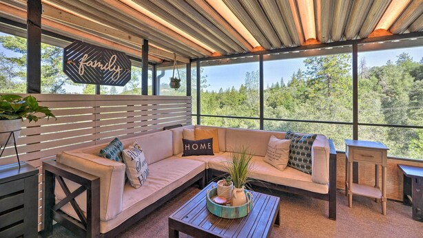 A modern outdoor seating area with a wooden ceiling, a 'family' sign, and a 'home' sign on the sofa. - Jackson Escape w/ Hot Tub & Mtn Views! (Jackson)