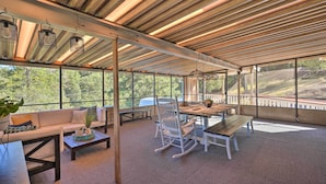 A covered outdoor seating area with a wooden ceiling, large windows, and a view of the outdoors. - Jackson Escape w/ Hot Tub & Mtn Views! (Jackson)