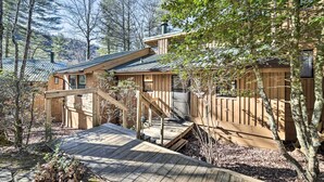 A wooden cabin with a deck, surrounded by trees. - Sapphire Home w/ Grill & Pool Access (Sapphire)