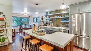 A modern kitchen with a central island, stainless steel appliances, and pendant lighting. - Fishing & Rafting: Mckenzie River Cabin! (Blue River)