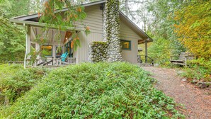 A cabin with a stone chimney, a porch with blue chairs, and a wooden deck. - Fishing & Rafting: Mckenzie River Cabin! (Blue River)