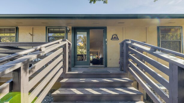 A set of concrete steps leading to a building entrance with a glass door and a metal railing. - Ruidoso Condo w/ Golf View ~ 17 Mi to Ski Apache! (Ruidoso)