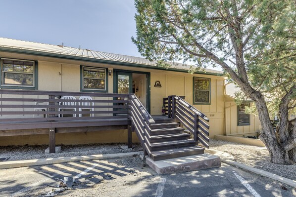 A building with a staircase leading to a door, a bench outside, and a tree nearby. - Ruidoso Condo w/ Golf View ~ 17 Mi to Ski Apache! (Ruidoso)