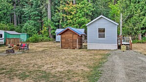 A campground with cabins, a covered picnic area, and a dirt path leading to a parking area. - Woodsy Packwood Haven w/ Golf Course Access! (Packwood)