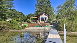 A riverside property with a dock, a small house, and a gazebo. - Quaint Oakland Getaway on East Pond Lake! (Oakland)