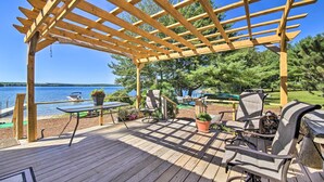 A wooden deck with outdoor furniture, a pergola, and a view of the lake. - Quaint Oakland Getaway on East Pond Lake! (Oakland)