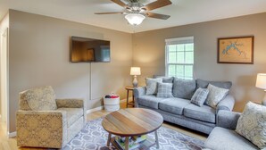 A living room with a grey sofa, patterned armchair, and a wooden coffee table. - Walk to Main St: Inviting Byrdstown Home w/ Yard! (Byrdstown)