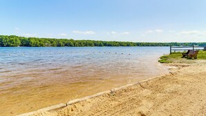 A sandy beach with a wooden bench and a metal railing. - ~ 1 Mi to Lake: Secluded Poconos Home w/ Decks (Jim Thorpe)