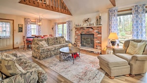 A cozy living room with a fireplace, wooden beams, and a dining area. - ~ 1 Mi to Lake: Secluded Poconos Home w/ Decks (Jim Thorpe)