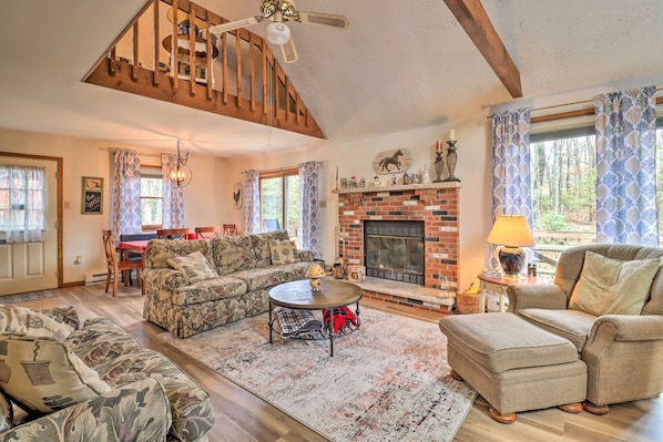 A cozy living room with a fireplace, wooden beams, and a dining area. - ~ 1 Mi to Lake: Secluded Poconos Home w/ Decks (Jim Thorpe)