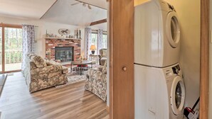A living room with a sofa, a fireplace, and a washing machine. - ~ 1 Mi to Lake: Secluded Poconos Home w/ Decks (Jim Thorpe)