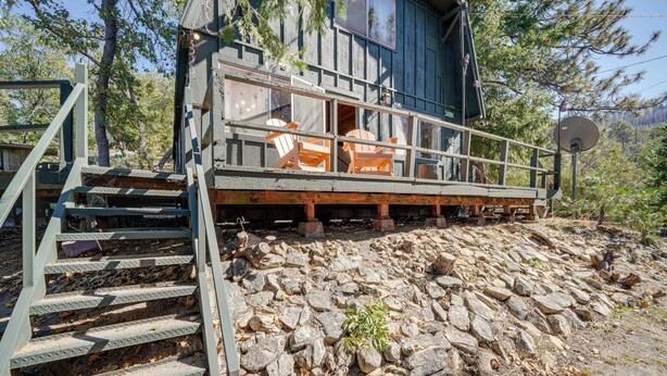A cabin with a wooden deck, outdoor seating, and a stone retaining wall. - Quiet Sequoia National Forest Cabin w/ Fireplace (Posey)