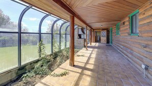 A covered corridor with wooden walls and large windows. - Spacious Pinedale Home w/ Mountain Range View (Pinedale)