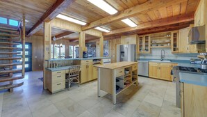 A spacious kitchen with wooden cabinets, a central island, and a built-in stove. - Spacious Pinedale Home w/ Mountain Range View (Pinedale)