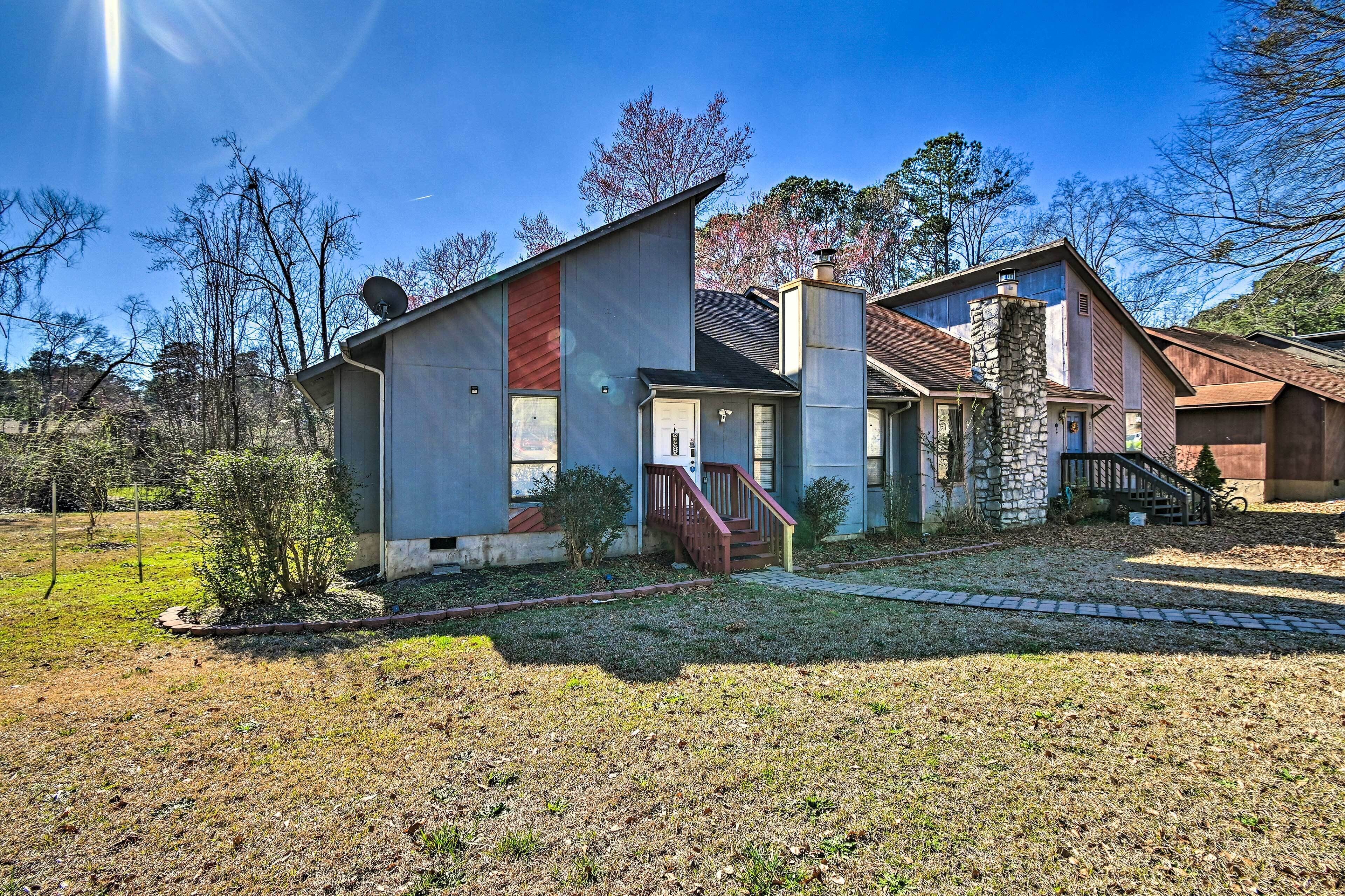 A modern two-story house with a stone chimney, a small front porch, and a well-maintained lawn.