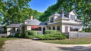 A two-story house with a covered front porch, a fenced yard, and a gravel driveway. - Southwest Harbor Home-3 Min to Acadia Natl Park (Southwest Harbor)