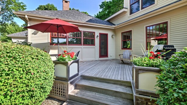 A house with a wooden deck, a red umbrella, and a barbecue grill. - Southwest Harbor Home-3 Min to Acadia Natl Park (Southwest Harbor)