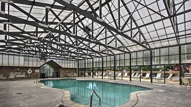 An indoor swimming pool with a glass ceiling, surrounded by lounge chairs and a small building. - Sevierville Cabin w/ Hot Tub, Views & Pool Access! (Sevierville)