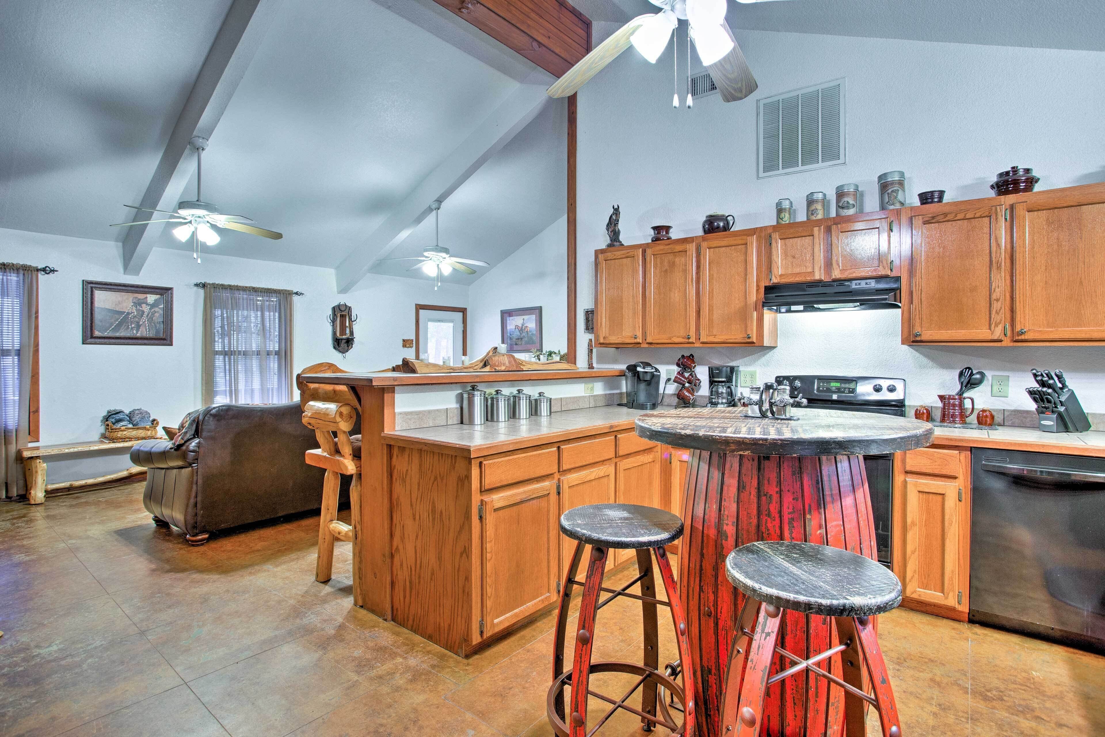 A spacious kitchen with wooden cabinets, a central island, and a dining area with stools.
