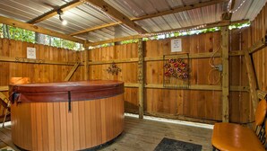 Uma área de spa com madeira, incluindo uma banheira de hidromassagem, uma cadeira e um painel decorativo.