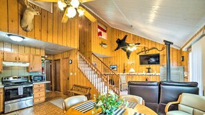 A wooden interior with a kitchen, dining area, and seating. - Secluded Woodsy Watersmeet Cabin w/ Fire Pit! (Watersmeet)