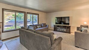 A spacious living room with a large flat-screen TV, two sofas, and a fireplace. - Willow Creek Hideaway w/ Deck, 1 Mi to River! (Willow Creek)