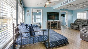A bedroom with a bed, a ceiling fan, a TV, and a fireplace. - 1 Block to Surfside Beach: Home w/ Deck! (Freeport)