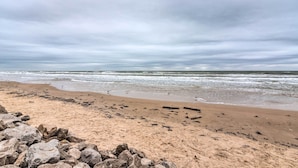 A beach with a rocky foreground and waves in the background. - 1 Block to Surfside Beach: Home w/ Deck! (Freeport)