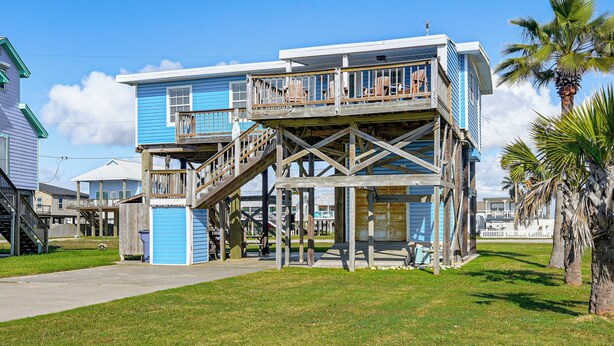 A multi-story building with a wooden deck, a staircase, and a view of the surrounding area. - 1 Block to Surfside Beach: Home w/ Deck! (Freeport)