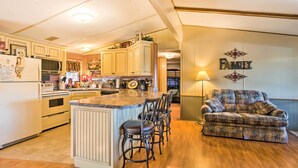 A spacious kitchen with a central island, bar stools, and a family-themed wall decoration. - Waterfront House w/ Boat Slip on Lake Eufaula! (Canadian)