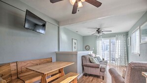 A cozy living room with a wooden bench, a sofa, and a dining table. - York Beachfront Condo - Steps to Long Sands! (York Beach)